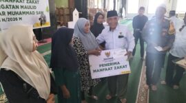 BANTUAN - Ketua Baznas Kota Ternate, Drs. H. Adam Ma'rus, M.Pd.I, menyerahkan bantuan konsumtif secara simbolis kepada perwakilan warga penerima manfaat di Masjid Agung Almunawar Ternate, Selasa (25/8/2026). (Dok: Baznas Ternate).