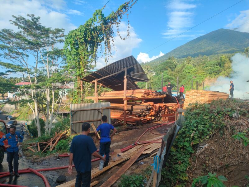 KEBAKARAN - Petugas pemadam kebakaran melakukan proses pendinginan di lokasi Pangkalan Kayu Udiffa, Kelurahan Sangadji Utara, Kota Ternate, Sabtu (15/8/2026), setelah api berhasil dipadamkan. Kebakaran menghanguskan sebagian tempat usaha dan material kayu, dengan kerugian sementara ditaksir mencapai ratusan juta rupiah. (Dok: Istimewa).