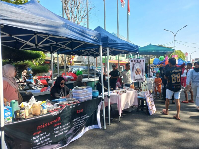 PELAKU USAHA - Pelaku UMKM Kedai Numi melayani pengunjung di area Car Free Day (CFD) Taman Nukila, Kota Ternate, Minggu (16/8/2026). Kehadiran CFD menjadi peluang bagi Kedai Numi untuk menjangkau pelanggan baru dan meningkatkan penjualan. (Dok: Wahana Malut/Tia).