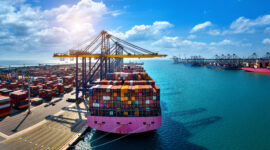 Aerial view of cargo ship and cargo container in harbor.